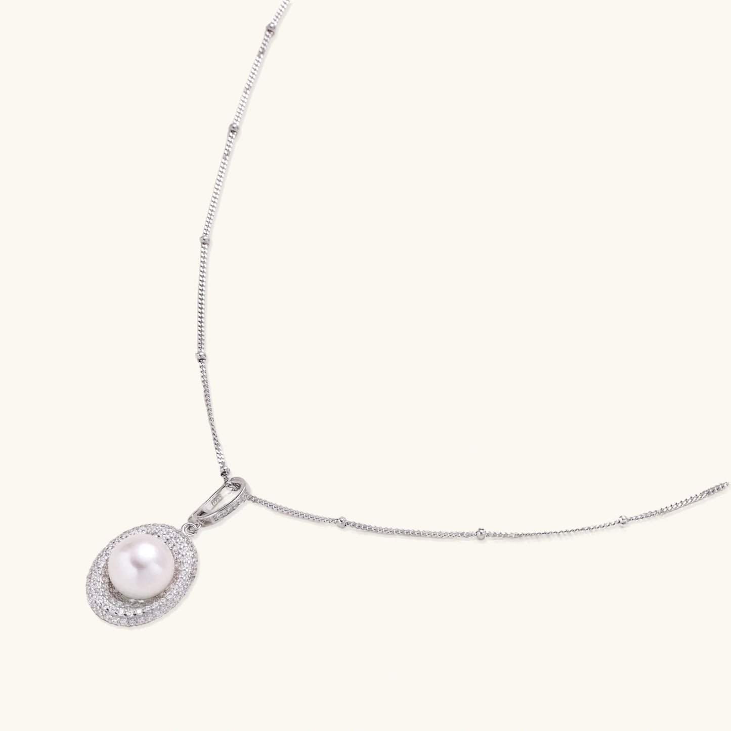 Oval sterling silver pendant with crystal halo surrounding a white freshwater pearl on delicate chain