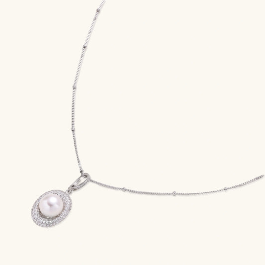 Oval sterling silver pendant with crystal halo surrounding a white freshwater pearl on delicate chain