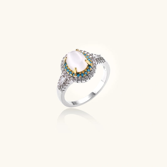 Vintage-style cocktail ring with luminous cat's eye center stone surrounded by turquoise and crystal double halo on white gold plated band