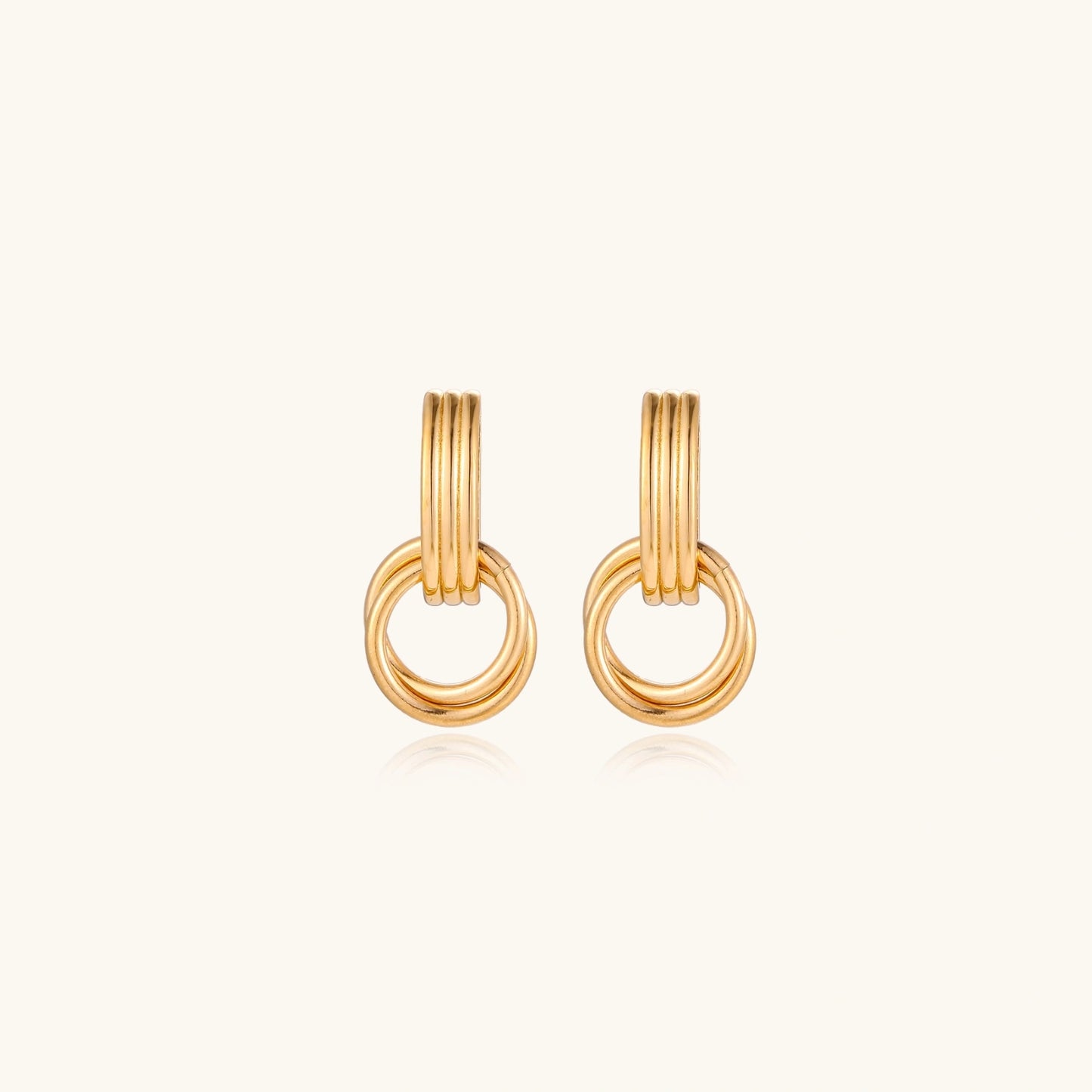 Gold stud earrings with vertical ridged bar connecting to triple interlocking circular rings on white background
